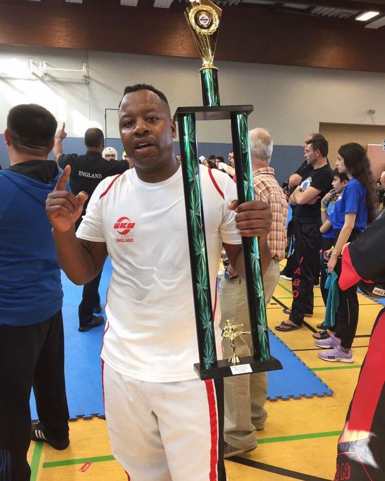 Linvell Taylor, founder of Taylor's Martial Arts, holding a WKU England competition trophy