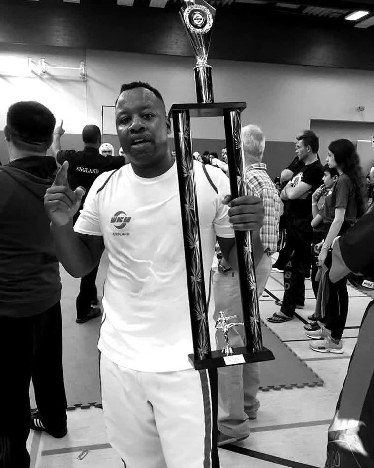 Linvell Taylor, founder and head coach at Taylor's Martial Arts, holding a championship trophy